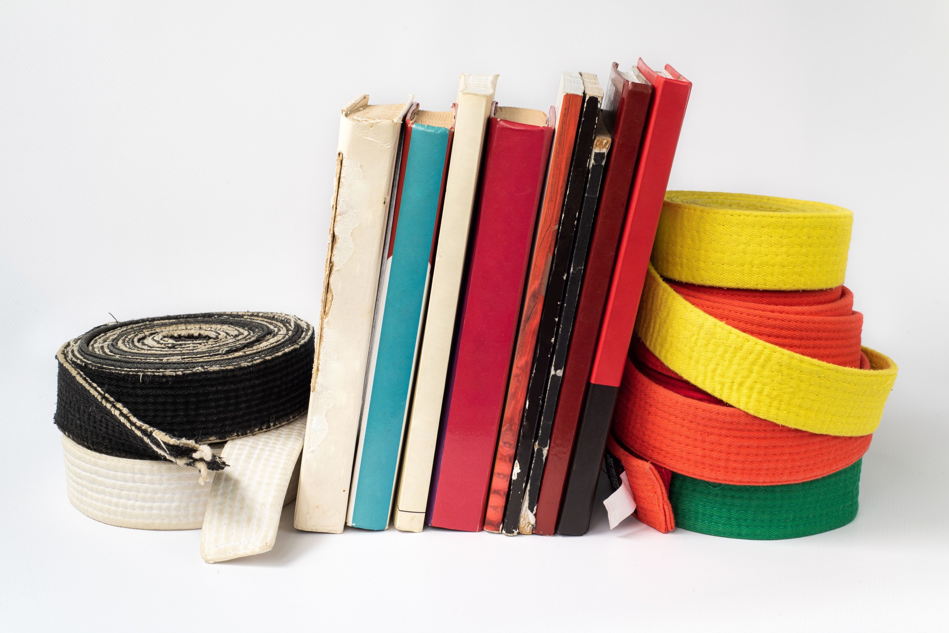 Black and white martial arts belt on a stack of books on the study of martial arts of aikido, karate, judo. Body and mind developmen